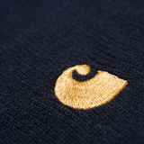 Carhartt WIP Chase Beanie em azul marinho com logo bordado em dourado. Foto de detalhe do logotipo na frente.