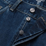 Carhartt WIP Newel Pant em azul com lavagem Stone Washed. Foto de detalhe dos botões da braguilha.