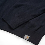 Carhartt WIP Playoff Turtleneck Sweater Dark Navy. Foto de detalhe do logotipo na parte de baixo da camisola e do punho.